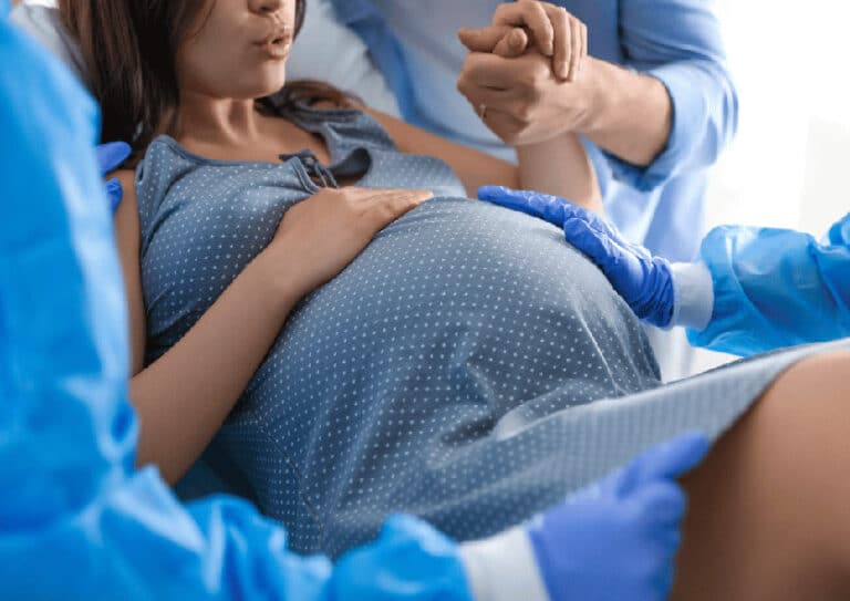 Schwangere Frau bei Entbindung mit Hebamme