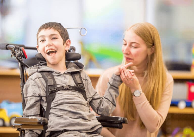 Heilerziehungspflegerin betreut Jungen im Rollstuhl